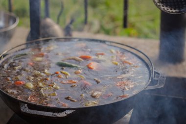 Tavada kaynatılmış çorba. Çaydanlık yanıyor. Turistik yiyecekler. Ana yemek hazırlığı. Kaynamış et çorbası. Kamp ateşinde esrar. Piknik yemeği. Çorba tarifi. 