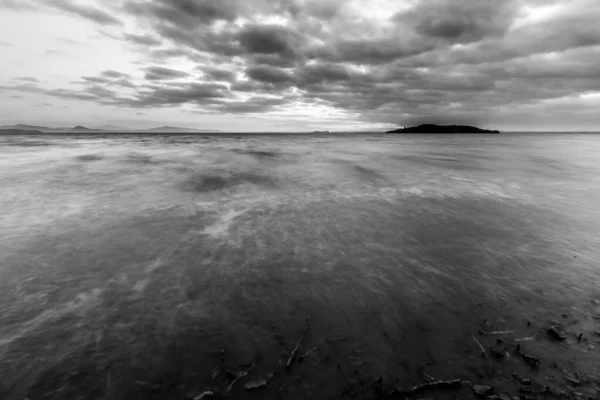 Shore of Trasimeno lake Umbria, Italy with moody clouds and island at the distance — Stock Photo, Image