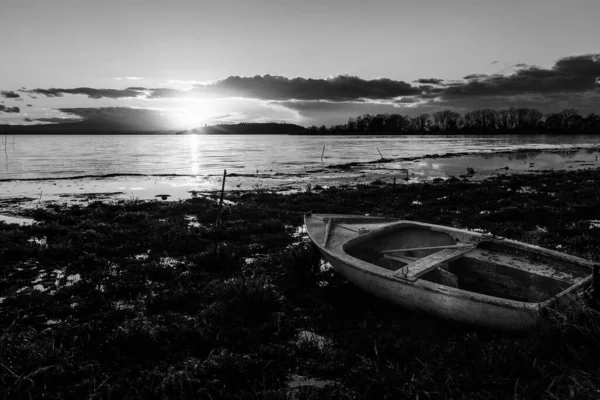 Vista da costa do lago Trasimeno Úmbria, Itália com um pequeno barco ao pôr do sol — Fotografia de Stock