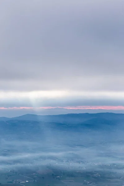 Солнечные Лучи Спускаются Облаков Над Долиной Заполненной Туманом Освещающим Часть — стоковое фото