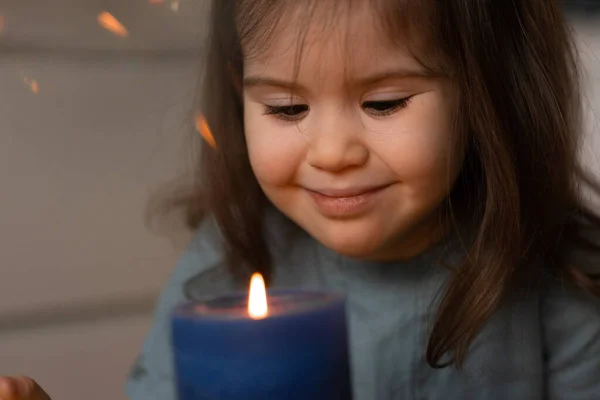 Çok tatlı bir kız çocuğu. Mumlara bakarak gülümsüyor..
