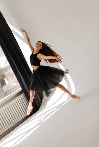 Mooie ballerina dansen in studio in zwarte jurk, hebben training. — Stockfoto