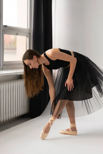 Mooie ballerina dansen in studio in zwarte jurk, hebben training. — Stockfoto