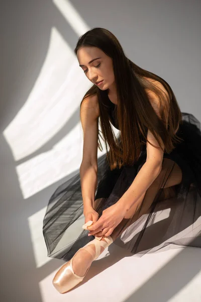 Balerin, kurdeleleri bale ayakkabılarıyla bağlar..