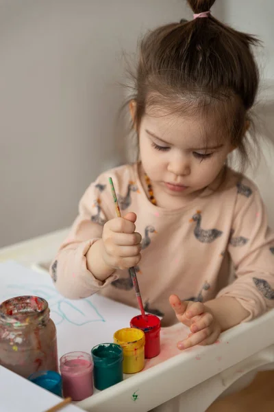 Evinde renkli resimler çizen güzel bir kız bebek..