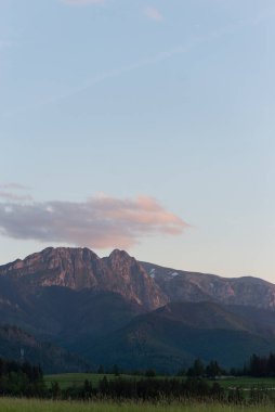 Gün batımında Zakopane 'deki Polonya Kapratian Dağları' nın güzel manzarası. Güzel yeşil çimenler, pembe ve mor gökyüzü ve Polonya 'da Rysy ve Morse Oko kayaları..