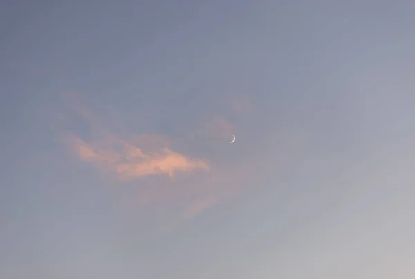 Genç aylı güzel günbatımı gökyüzü. Akşamları bulutların inanılmaz renkleri. Doğa kavramı. 