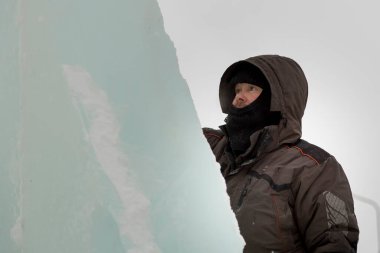 Kar maskeli bir işçi ve kafasında da bir kapüşon var.