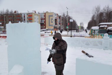 Kış tulumlu bir ustanın portresi. Buz panelinde elinde bir işaret var.
