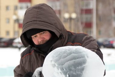Heykeltıraş, buzdan bir heykeli Noel için keskiyle kesiyor.