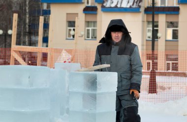 İş yerindeki erkek montajcının portresi. Kış tulumuyla.