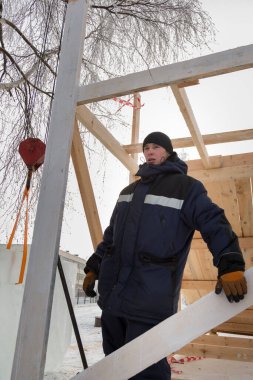 Ahşap bir yapı oluşturmakla meşgul bir işçinin portresi