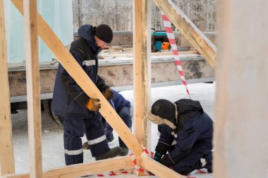 İşçiler ahşap bir kaydırağın çerçevesini birleştiriyorlar