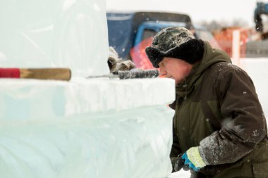 Kulaklık takmış bir işçinin yüz portresi. Buz kasabasını düzenlemekle meşgul.