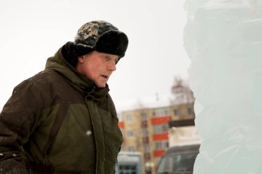 Kulaklık takmış bir işçinin yüz portresi. Buz kasabasını düzenlemekle meşgul.