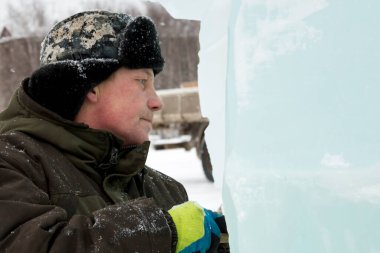 Kulaklık takmış bir işçinin yüz portresi. Buz kasabasını düzenlemekle meşgul.