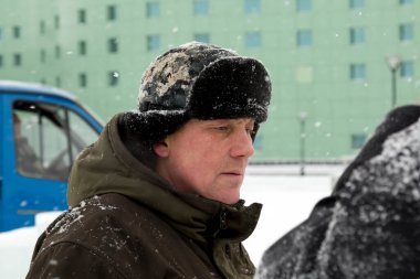 Kulaklık takmış bir işçinin yüz portresi. Buz kasabasını düzenlemekle meşgul.