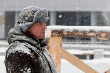 Heykeltıraş, buzdan bir buz figürünü Noel için elektrikli testere ile kesiyor.