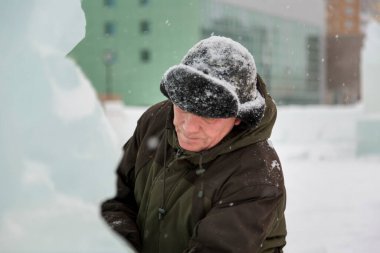 Kulaklık takmış bir işçinin yüz portresi. Buz kasabasını düzenlemekle meşgul.