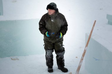 Buz kasabasındaki büyük bir buz panelinin arka planında çalışan bir işçi.