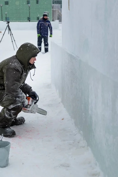 Trabalhador corta painel de gelo com serra a gasolina — Fotografia de Stock
