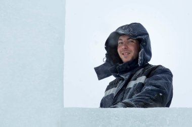 Bir ceket bir buz kampı inşaatı bir kukuleta ile bir assembler işçi portresi