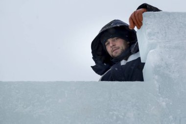 Bir ceket bir buz kampı inşaatı bir kukuleta ile bir assembler işçi portresi