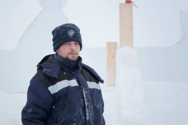 Bir ceket bir buz kampı inşaatı bir kukuleta ile bir assembler işçi portresi