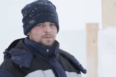 Bir ceket bir buz kampı inşaatı bir kukuleta ile bir assembler işçi portresi