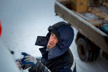 İş yerinde mavi ceketli bir işçinin yüzünü yakından çek.