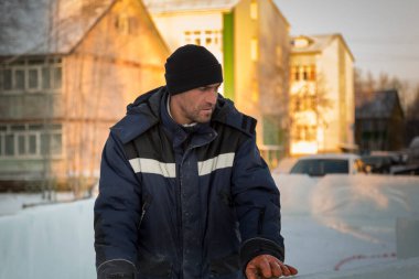 İş yerinde mavi ceketli bir işçinin yüzünü yakından çek.