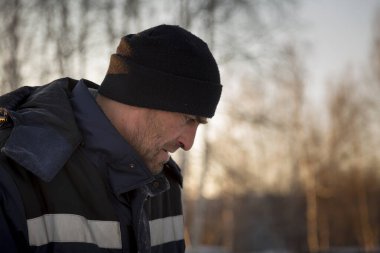 İş yerinde mavi ceketli bir işçinin yüzünü yakından çek.