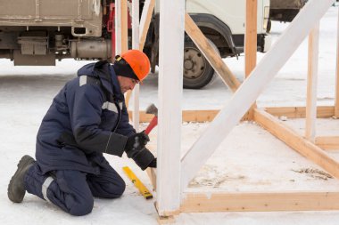 Ahşap bir yapı oluşturmakla meşgul bir işçinin portresi