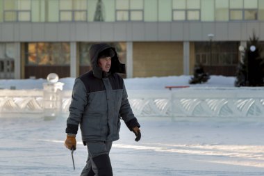 Kafasında başlığı olan, kışlık takım elbiseli bir müteahhit portresi.