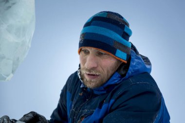 Heykeltıraş, buzdan bir heykeli Noel için keskiyle kesiyor.