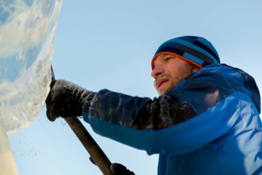 Heykeltıraş, buzdan bir heykeli Noel için keskiyle kesiyor.