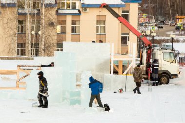 Heykeltıraş Noel için buz kalıbından bir buz heykeli kesiyor.