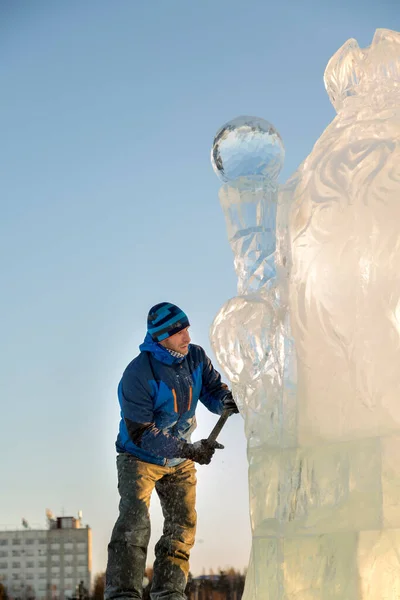 雕塑家用凿子从冰块上切下一个冰人 因为克莉丝汀在木制脚手架上 — 图库照片