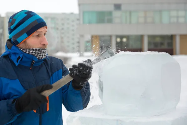 雕塑家用凿子从冰块中雕出一个圆形冰球 — 图库照片