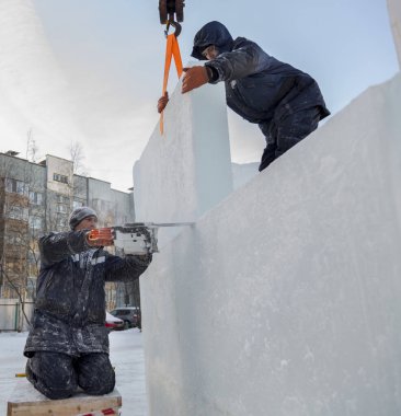 Tesisatçı, buz panelini bir benzin testeresiyle keser.