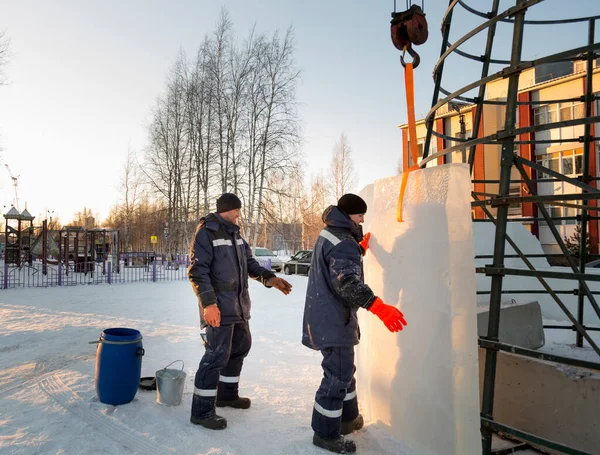 Buz kasabasının inşaatçıları Noel ağacını yüksek yeşil panellerle çevrelediler.