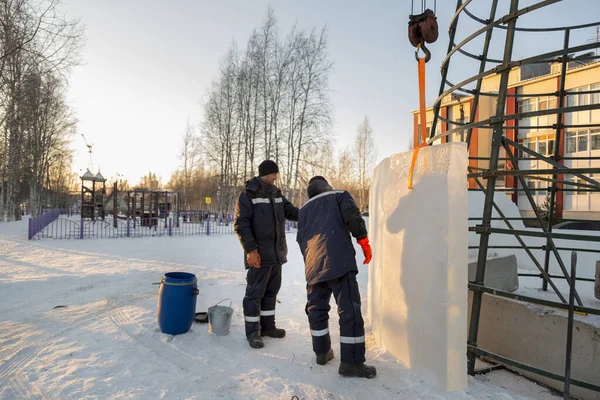 Buz kasabasının inşaatçıları Noel ağacını yüksek yeşil panellerle çevrelediler.
