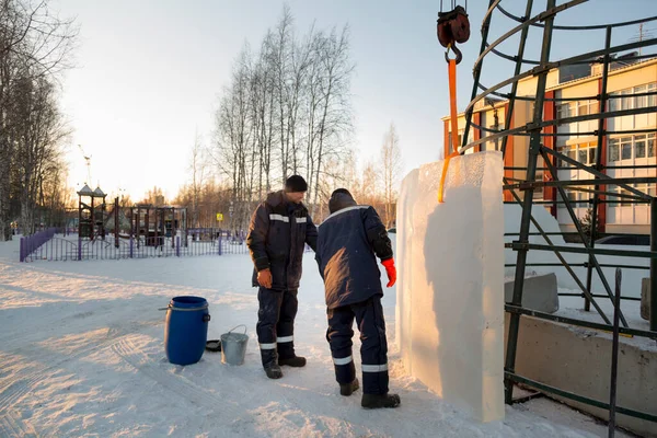 Buz kasabasının inşaatçıları Noel ağacını yüksek yeşil panellerle çevrelediler.