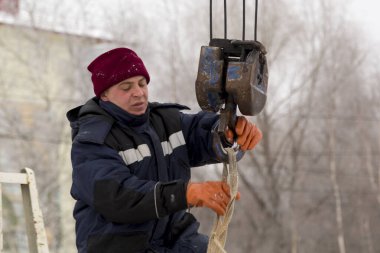 Kapüşonlu mavi ceketli bir işçinin portresi.