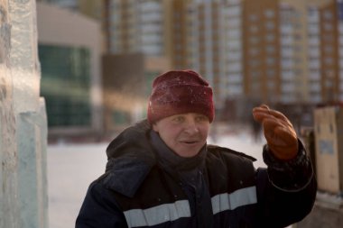 İş yerinde mavi kışlık ceketli bir adamın portresi.