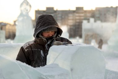 Heykeltıraş, buzdan bir buz figürünü Noel için elektrikli testere ile kesiyor.