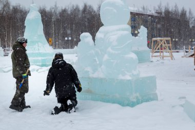 İnşaat alanındaki buz figüründeki yükleyiciler konuşuyorlar.