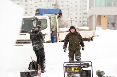 Bir konuşma için buz şehrin inşaat sahasında işçiler
