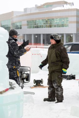 Bir konuşma için buz şehrin inşaat sahasında işçiler