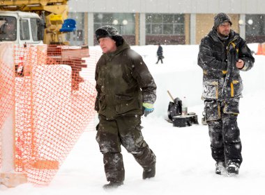 Buz kasabasının inşaat alanında iki toplayıcı yürüyor.